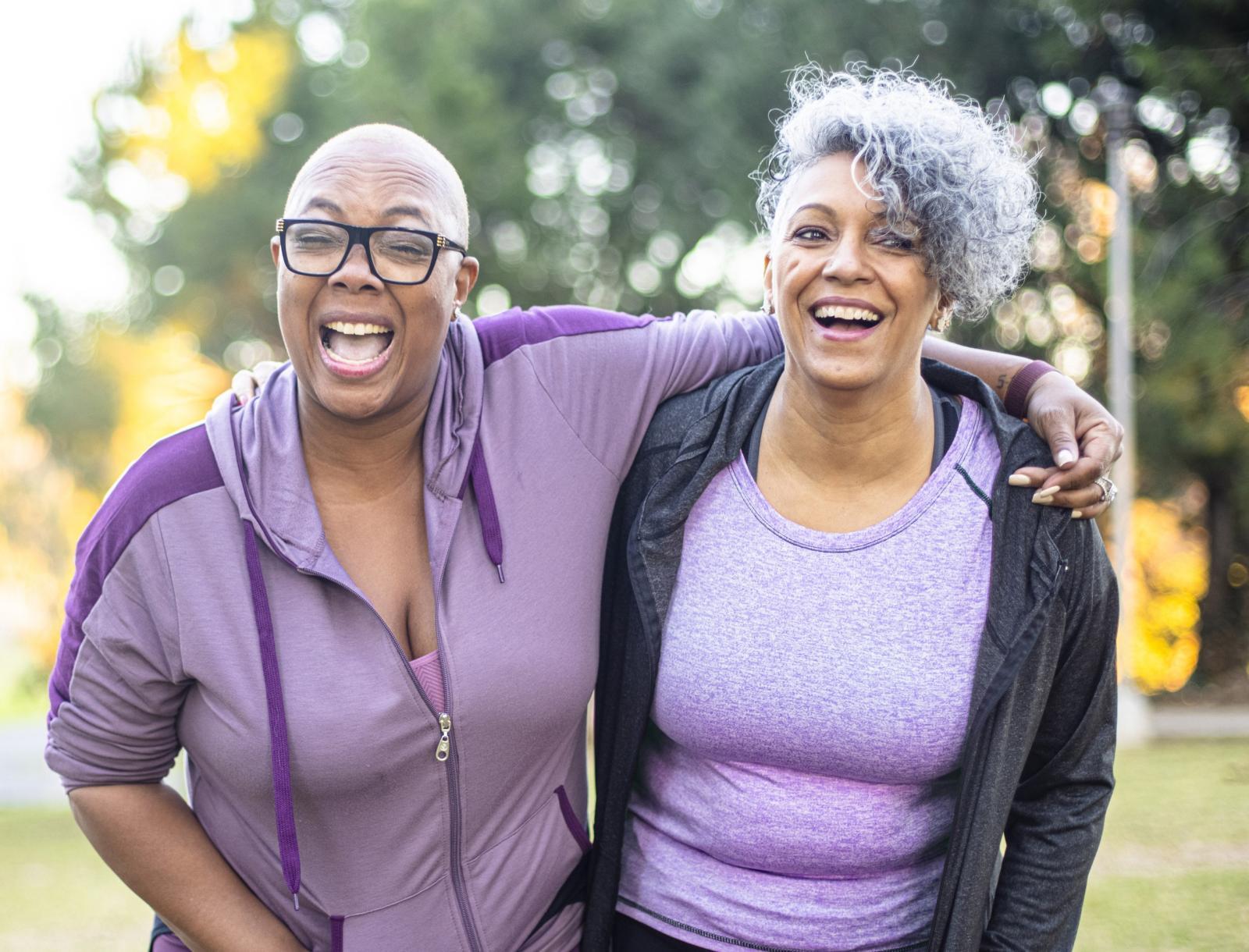 Two smiling women wearing purple exercise clothes